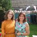 Chloe in a yellow dress stood next to her mum who is in a blue dress.