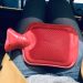 Red hot water bottle on my knees while wearing jeans