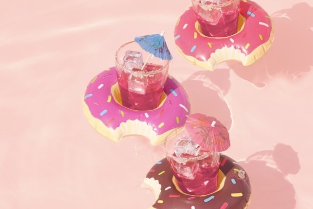 Donut with drinks and a pink background.